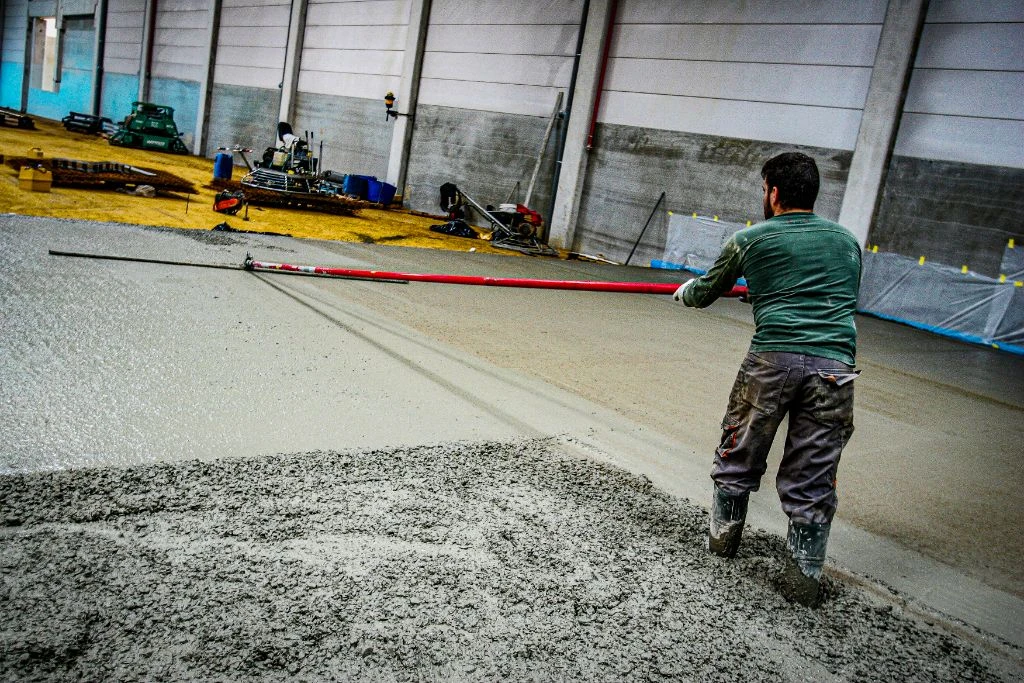 Ouvrier lissant le béton avec une règle