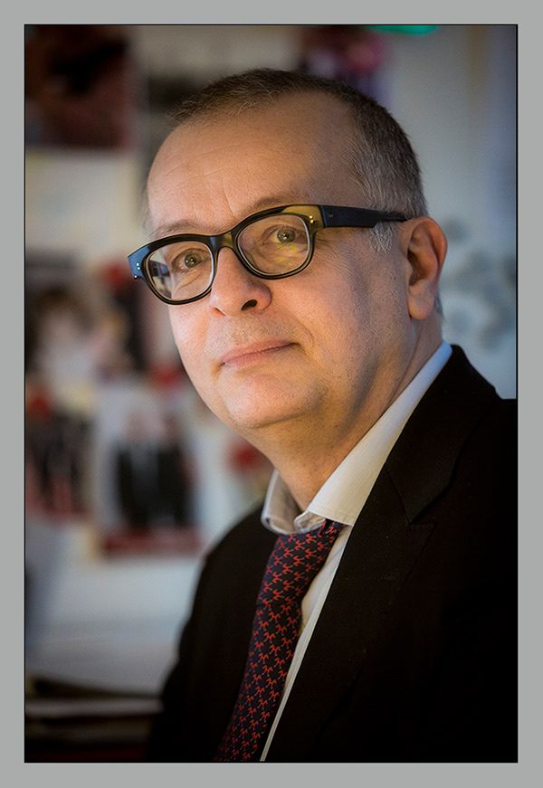 Portrait dirigeant avec lunettes en costume - fond flou professionnel